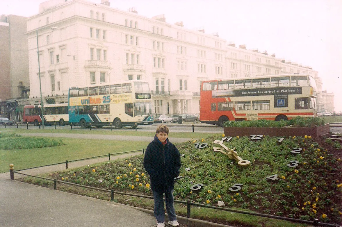 David frente al reloj floral de Brighton en 1997, con buses de dos pisos detrás