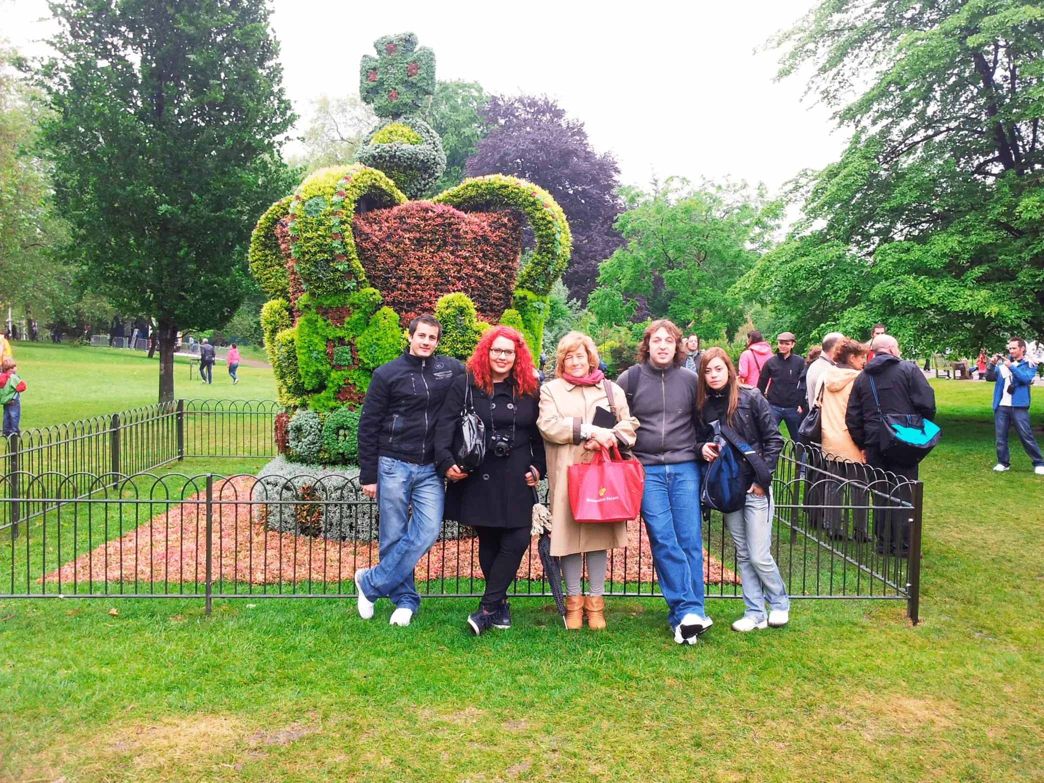 Grupo de jóvenes estudiantes en St James’s Park, Londres, junto a la corona floral